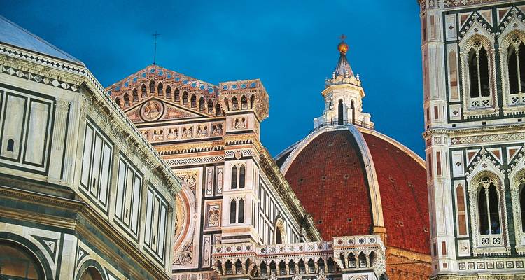 Close view of Florence Duomo and Giotto’s Campanile against a deep blue evening sky.