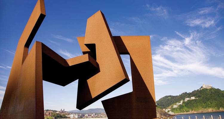 Modern art sculpture against a coastal backdrop.