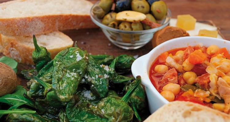 Le mont Teide se dresse au-dessus d'une mer de nuages avec des pins au premier plan.