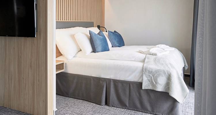 Cabine confortable avec un lit et des oreillers décoratifs dans un cadre moderne.