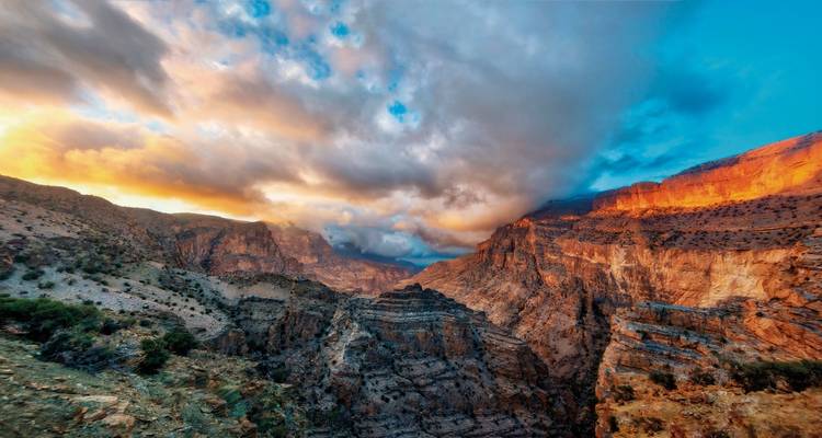 Paysage de canyon vivement illuminé au coucher du soleil.