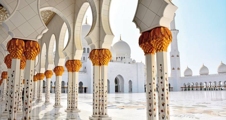 Impresionante mezquita con columnas que presentan oro y detalles ornamentados.