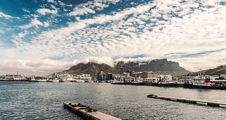 Hafenblick mit Docks und einer Bergkette im Hintergrund.
