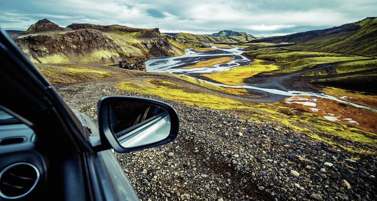 Vue du conducteur d'une route sinueuse à travers un paysage volcanique.
