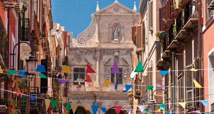 A historic street with colorful flags hanging overhead.