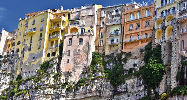 Grands bâtiments à flanc de falaise sous un ciel bleu dégagé.