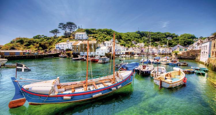 Coastal harbor with boats and cottages.