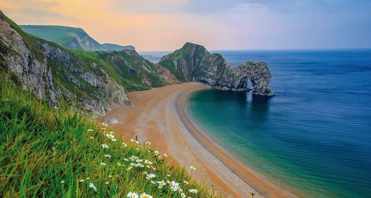 Durdle Door, ein natürlicher Kalksteinbogen mit einer Strandszene.