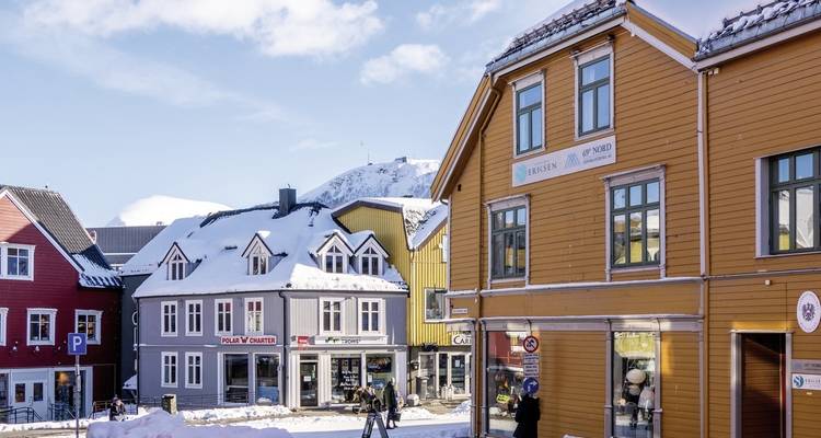 Vue de rue avec des maisons colorées couvertes de neige.