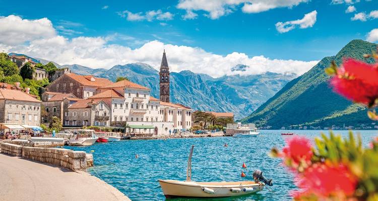Malerisches Dorf an einer Bucht mit Bergkulisse.