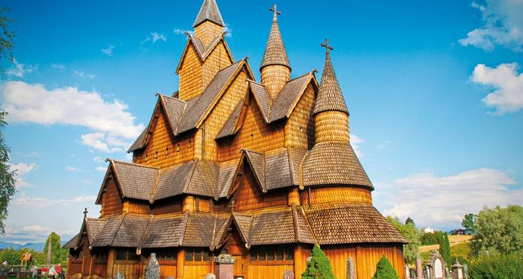 Une église traditionnelle en bois à douves avec plusieurs toits pentus.