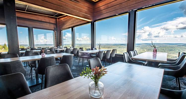 Salle à manger moderne avec fenêtres panoramiques offrant des vues panoramiques.
