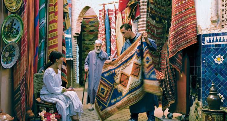 Mensen die kleurrijke textiel bekijken op een markt.