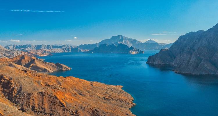 Majestueus uitzicht op bergen en serene blauwe wateren in een baai.