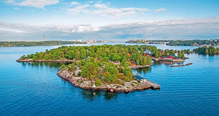 Scenic view of a small forested island surrounded by water.