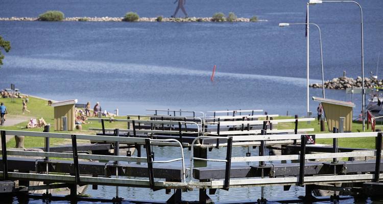 View of canal locks with distant people enjoying the day beside the water.