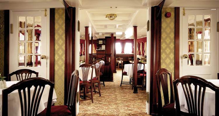 Interior of a vintage boat restaurant with classic wooden decor.