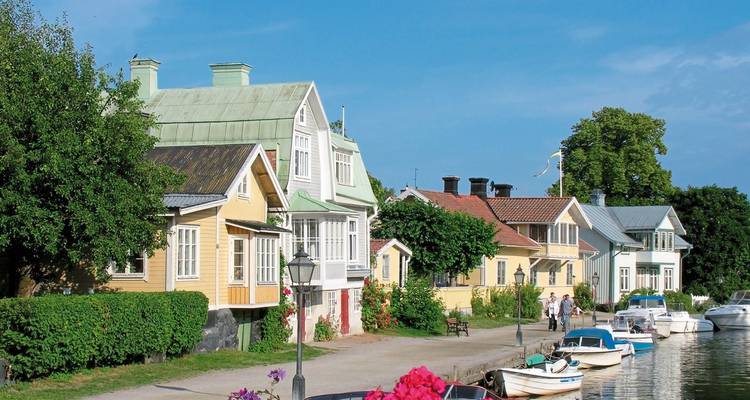Pintoresco paseo marítimo con casas coloridas y barcos en Suecia.