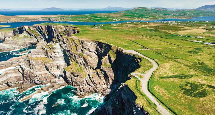 Luftaufnahme der steilen Atlantikklippen und der gewundenen Küstenstraße auf Valentia Island, Ring of Kerry.