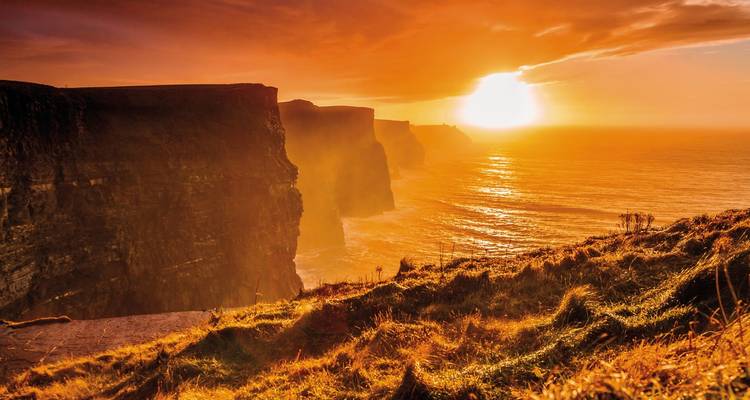 Falaises de Moher sous un ciel de coucher de soleil vibrant.