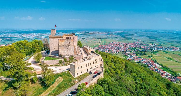 Burg auf einem Hügel mit Blick auf eine ländliche Landschaft mit kleinen Städten.