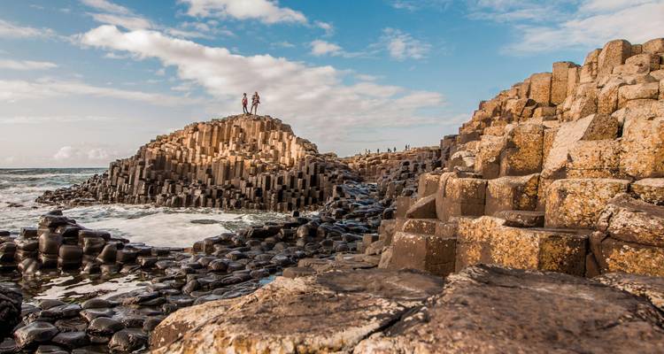 Giant's Causeway with visitors standing on the hexagonal rocks.