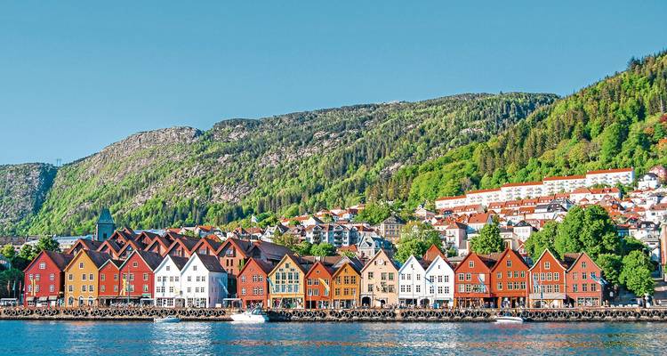 Colorful houses lining the waterfront with hills.