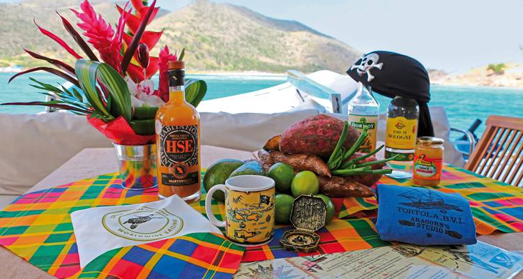 Fruits tropicaux et boissons disposés sur une table avec vue sur la plage.