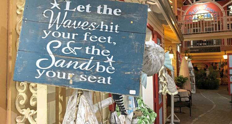 Decorative sign and shopfronts in a market area.