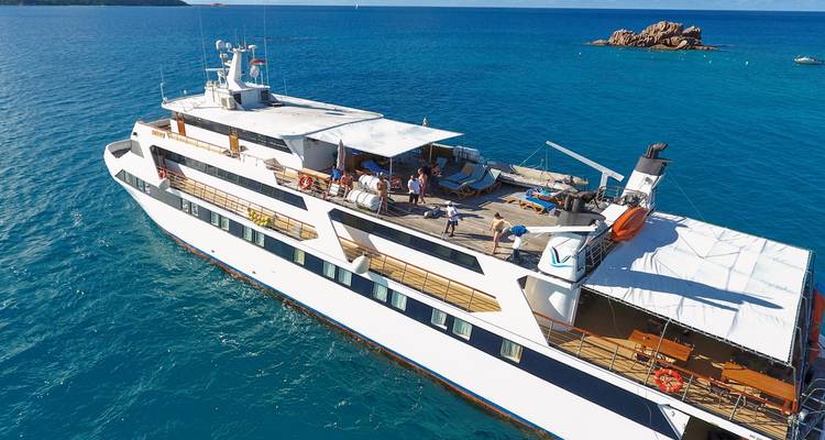 Een jacht op zee met een groep mensen aan dek.