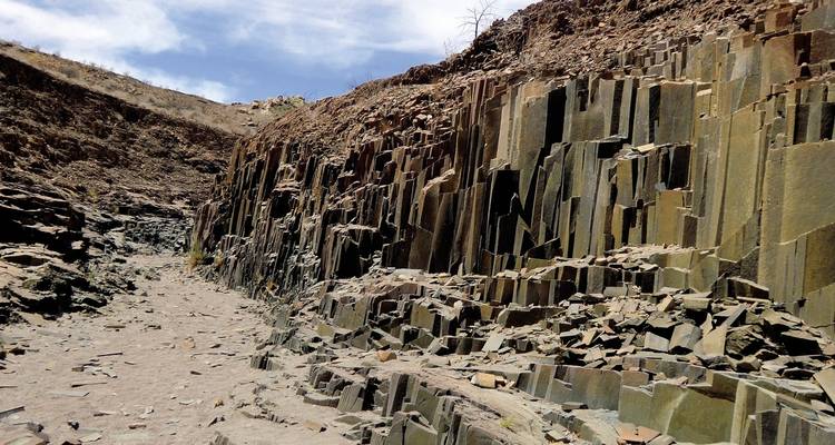 Rock formations with layered columns in a canyon.