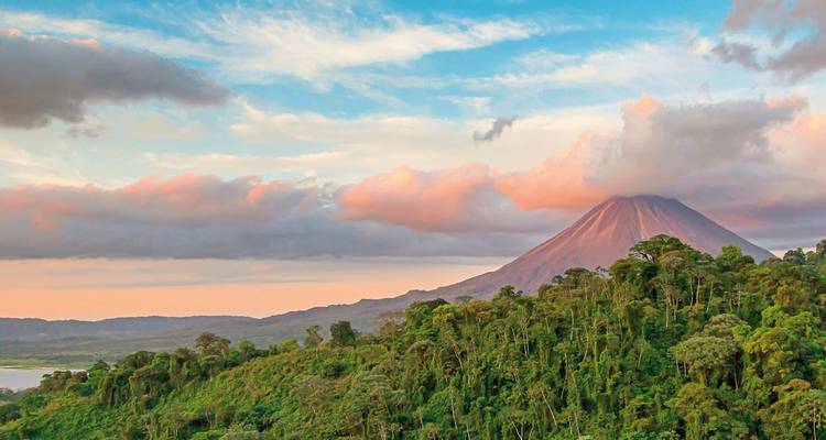 View of Arenal Volcano with dramatic sky and surrounding greenery.