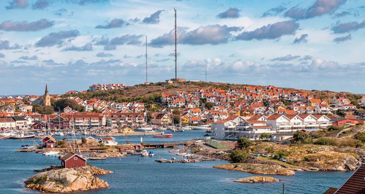 Ville côtière pittoresque avec des maisons aux toits rouges.