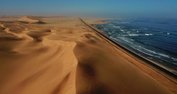 Luftaufnahme der Wüste, die auf das Meer trifft.