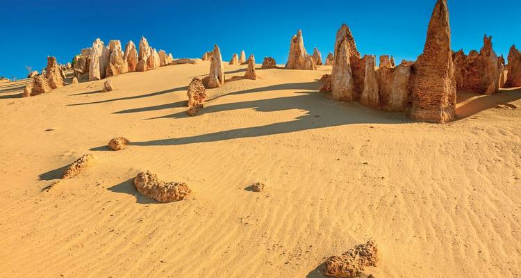 Woestijnlandschap met rotspinakels en een heldere blauwe lucht.