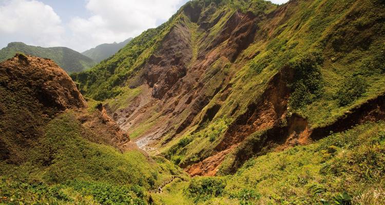 Lush, steep hills with lush green vegetation and a rugged valley.