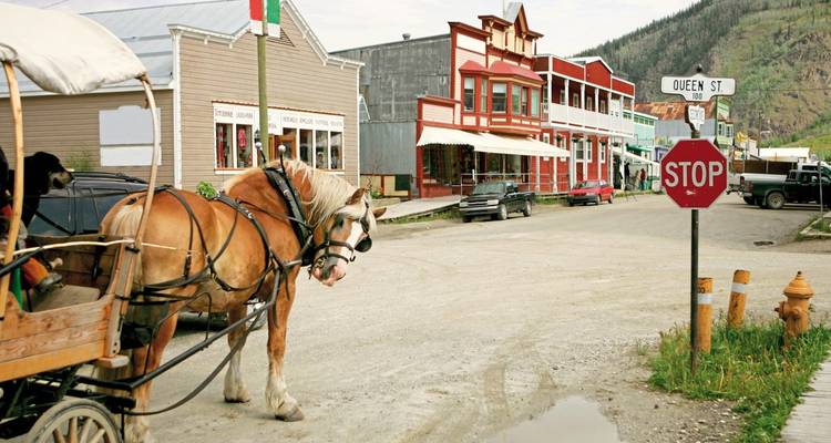 Rue de ville à l'ancienne avec calèche tirée par des chevaux.