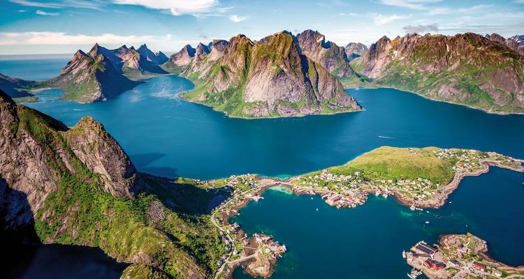 Aerial view of fjords with sharp mountainous peaks.