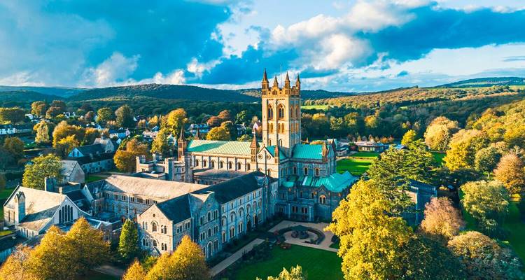 Vista aérea del complejo de la Abadía de Buckfast rodeado de árboles otoñales y colinas ondulantes