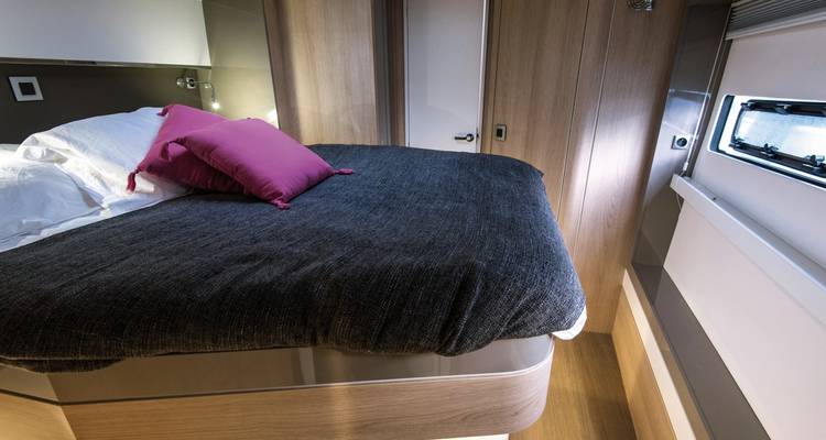 Interior cabin with partially made bed and window.