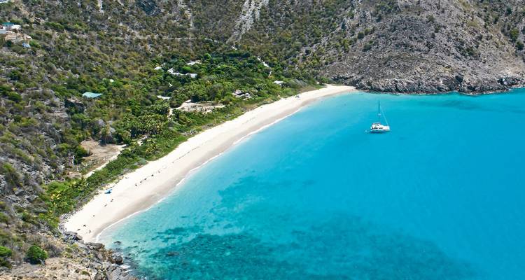 Luftaufnahme eines abgelegenen Strandes mit einer Yacht vor der Küste.