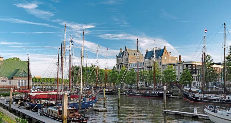 Un port avec des voiliers et des bâtiments historiques en arrière-plan.