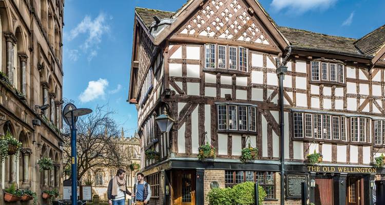 Traditional timbered building with people walking by.