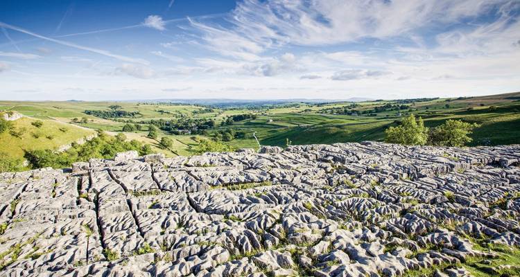 Rocky limestone pavement with a distant view of the countryside.