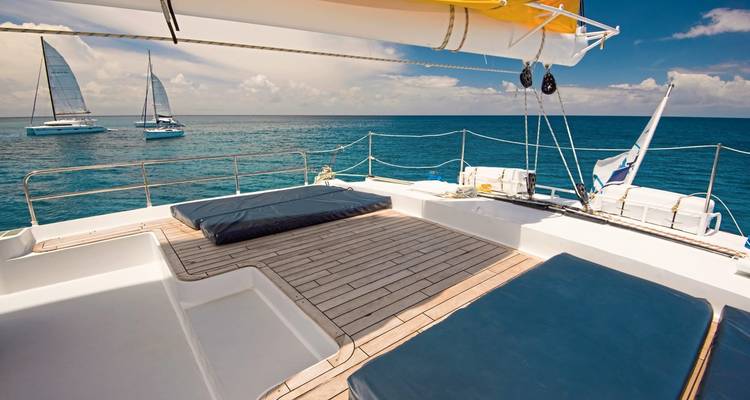 Blick vom Schiffsdeck mit zwei Katamaranen in der Ferne.