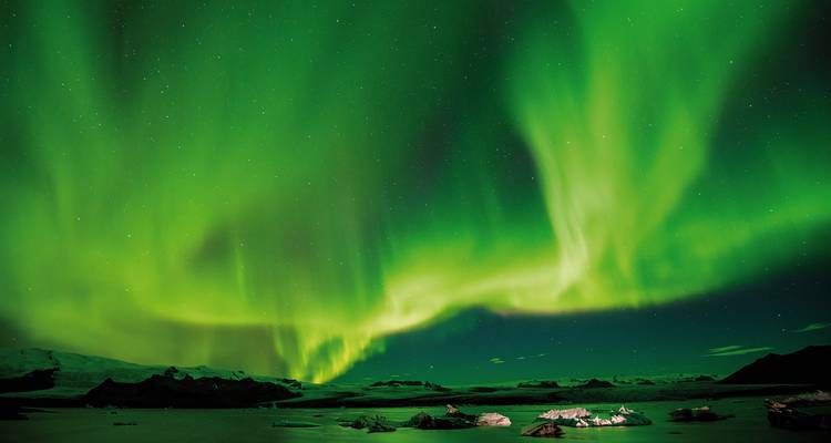 Stunning Aurora Borealis over a snowy, surreal landscape.