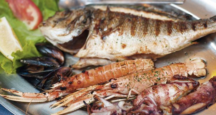 Seafood platter with various grilled and fried seafood items.