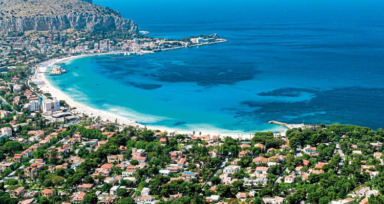 Vue aérienne d'une ville côtière avec une grande baie et une plage.