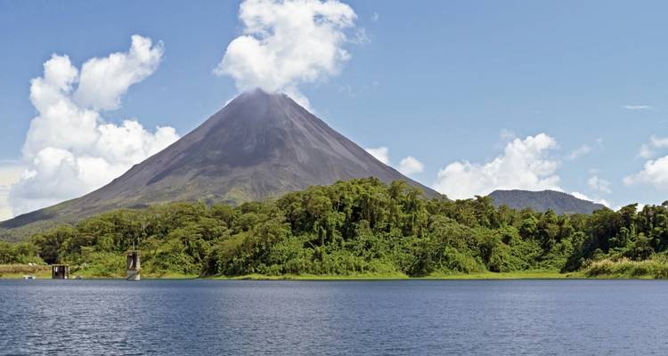 Montagne volcanique avec une végétation luxuriante et un ciel nuageux.