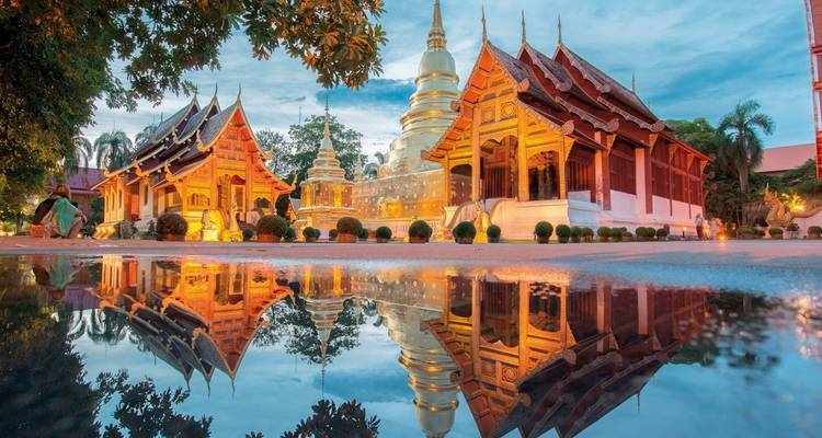 Complexe de temples aux flèches dorées et reflet dans l'eau.